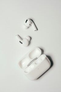 무선 블루투스 이어폰과 휴대용 충전 케이스, 깨끗한 흰색 디자인, 최신 기술, 음악 감상, 편리한 이동용 오디오 제품, 푸른곰의 모노로그, 테크 액세서리 이미지를 표현한 사진.